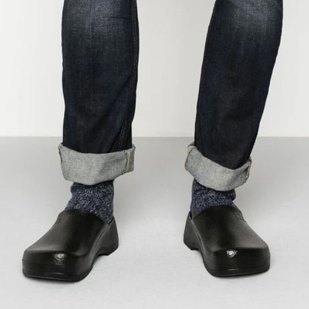 Birkenstock Super Birki PU Black Clogs worn with rolled jeans and socks, showing the durable, water-resistant design ideal for kitchens and medical environments.